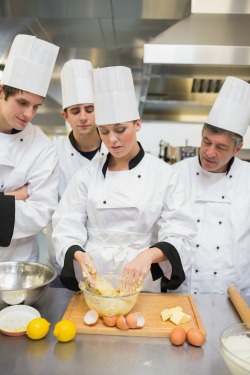 Trainees learning how to prepare dough in the kitchen