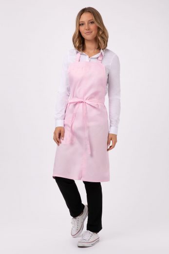 A woman wearing converse and Chef Works’ Brio Bib Apron in pink as part of Chef Works culinary uniform pieces